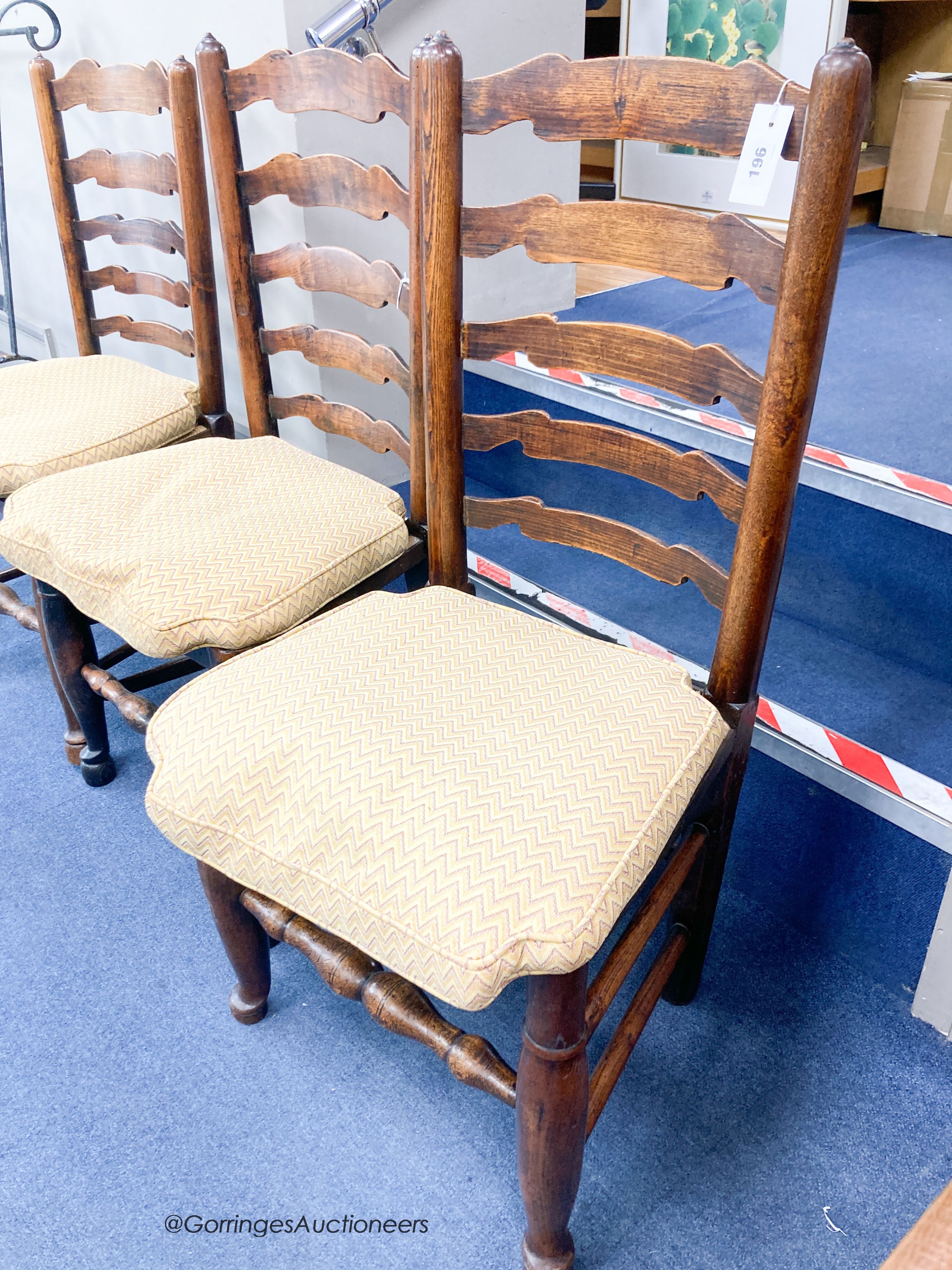 A harlequin set of eight ash rush seat ladder back dining chairs with squab seats